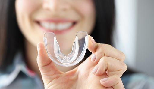 Close-up of woman holding a mouthguard
