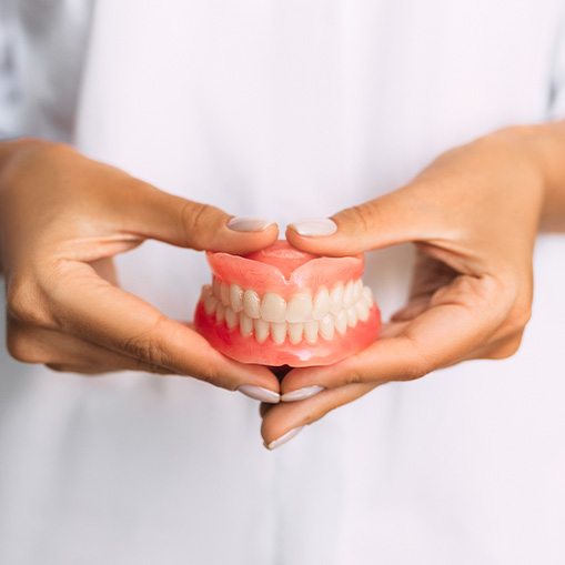 Lady presents viewer with dentures