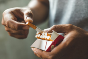 Close up of man slipping a cigarette out of the box